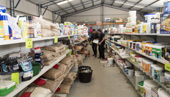 Two people inspecting bags of retail stockfeed