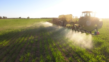Farm machinery spraying crop