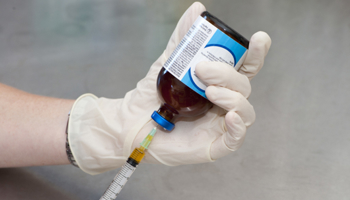 Drawing medicine into a syringe from a veterinary chemical bottle