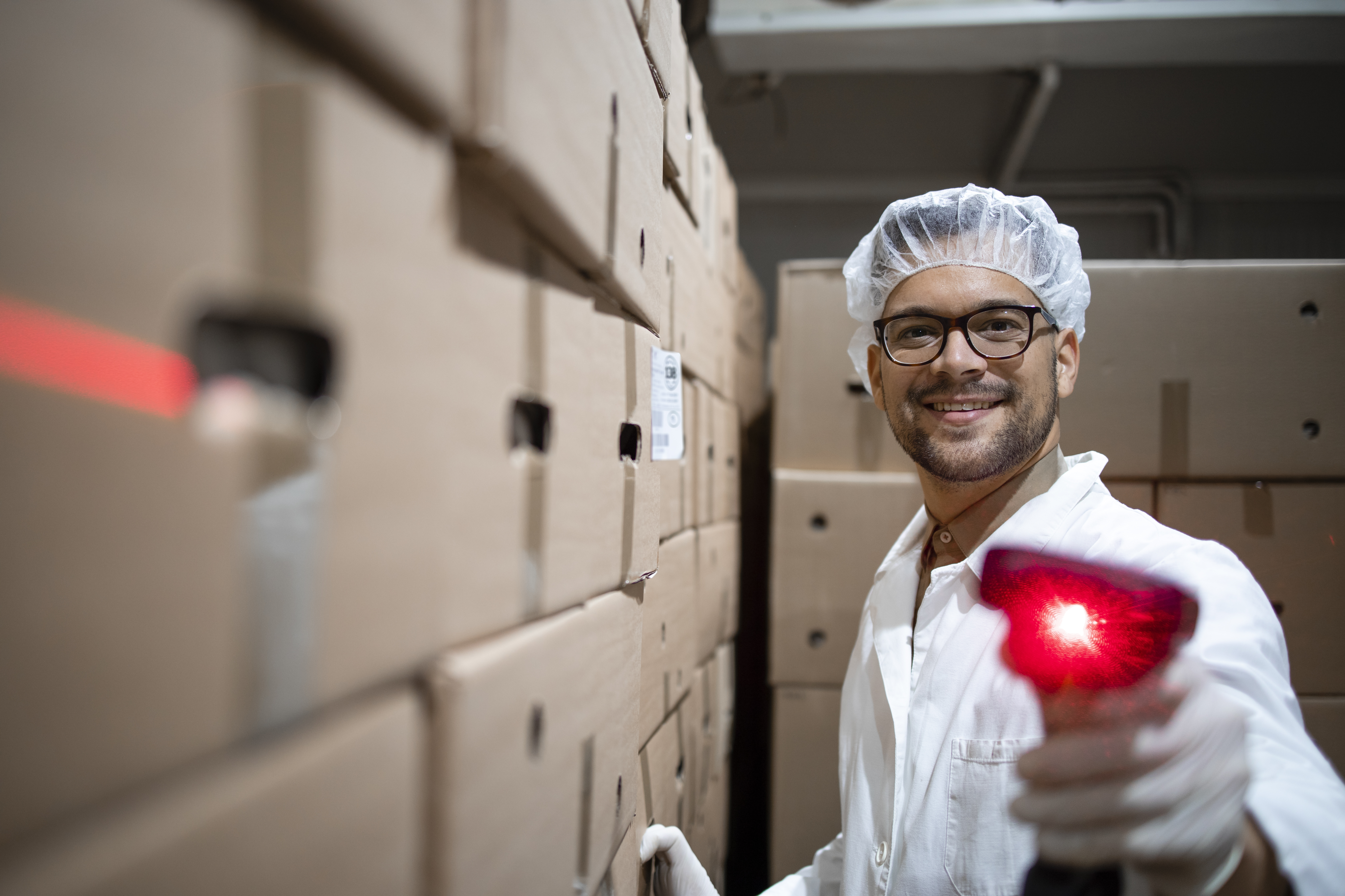Factory worker with hairnet holding bar code scanner