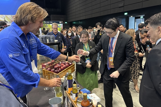 A wine exporter providing a tasting to a Japanese government official at an exhibition stand