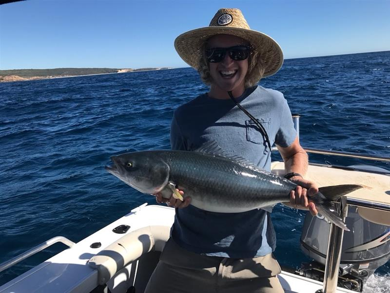 Man holding a WA salmon on a boat